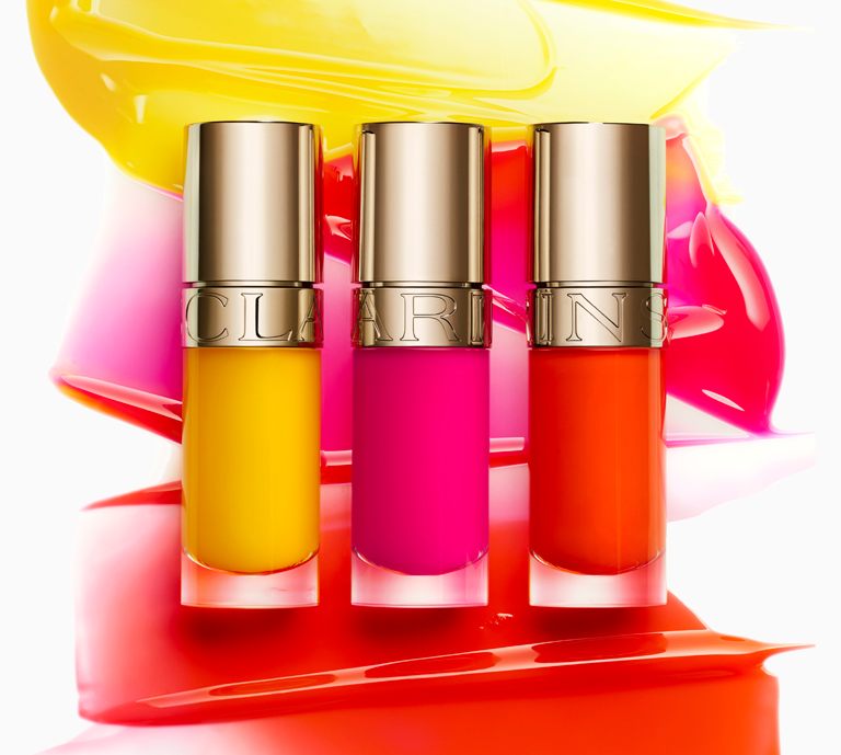 Hero image for Clarins limited edition neon Lip Oils displaying all three shades against colour swatches.