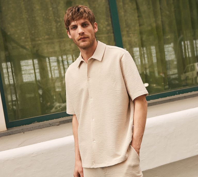 Image is of a man wearing a cream textured shirt