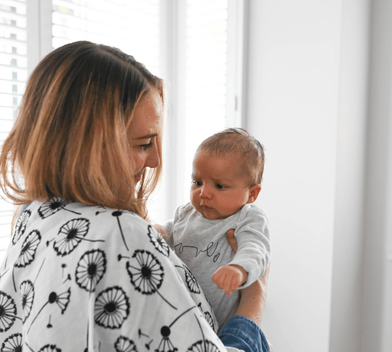 A baby looking at a dandelion muslin