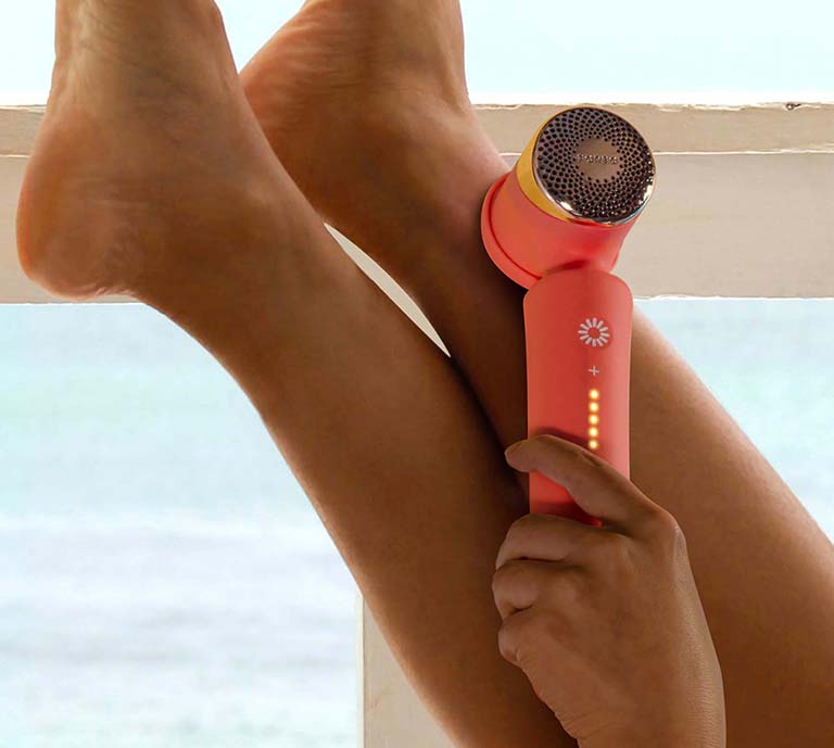 Woman applying Peach 2 IPL device to her legs.