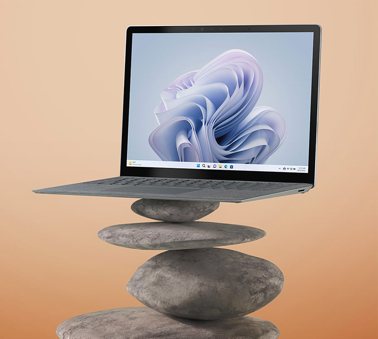 Microsoft Surface Laptop 5 sitting on stacked pebbles